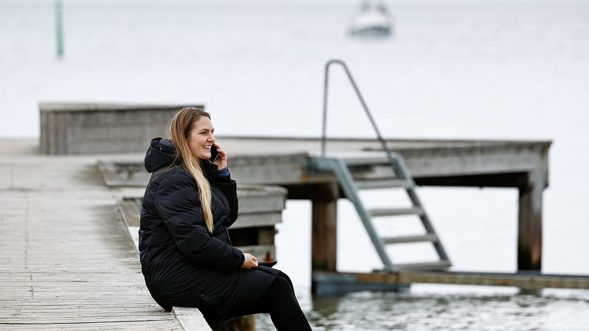 TDC NET Kvinde Ved Strand Siddende På Badebro Mobil Low Srgb