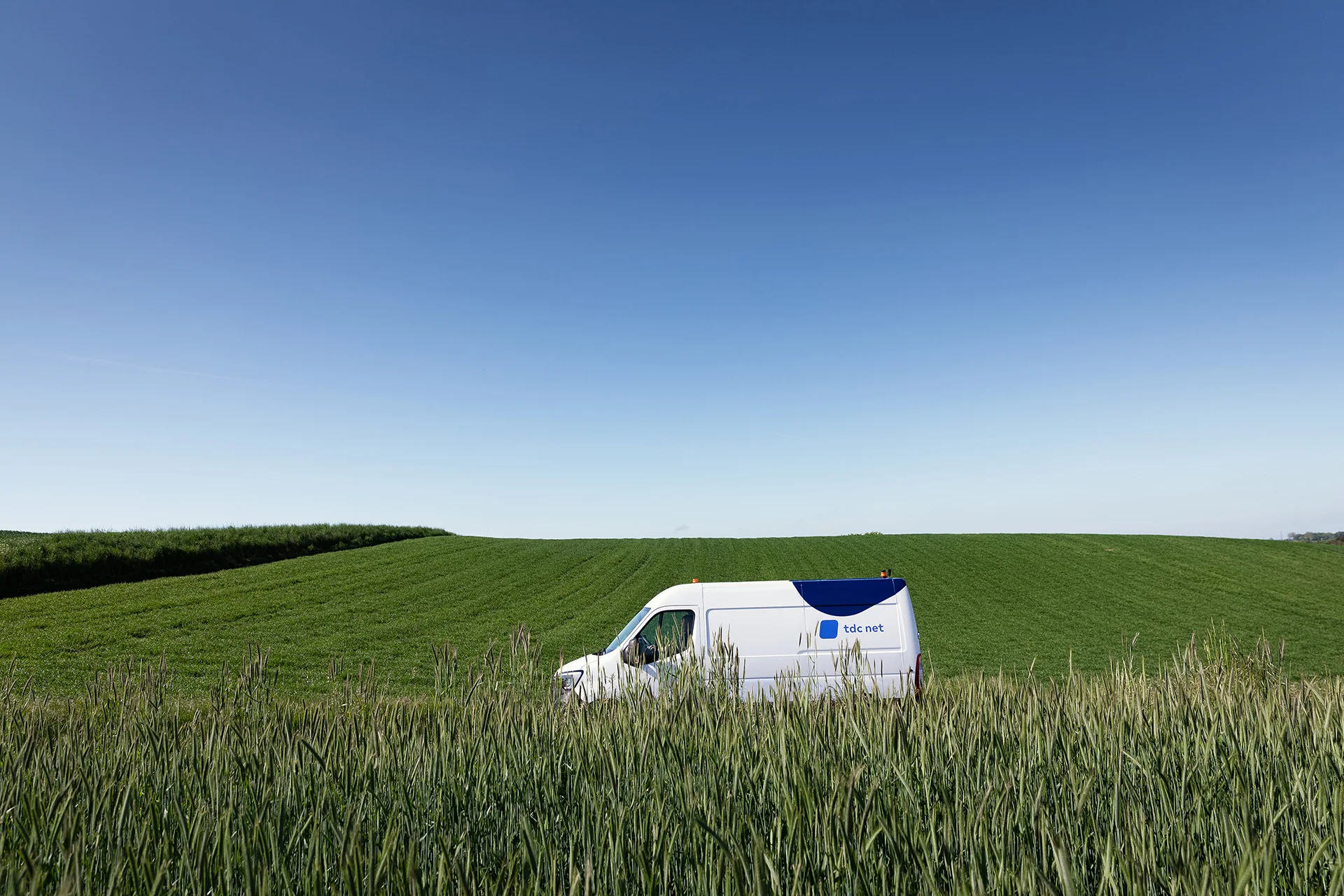 Teknikerbil kører ved kornmark